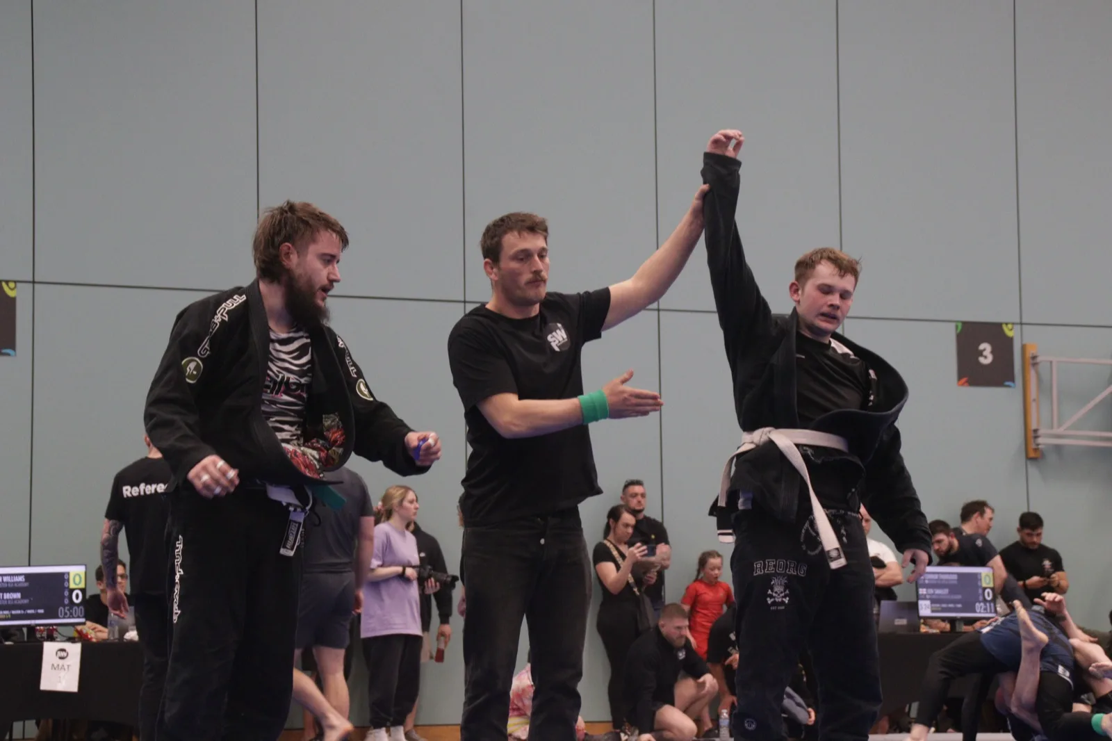 Referee raising Will's hand after a gold-medal win for Costello BJJ at SW Grappling 3 — Exeter BJJ on the podium